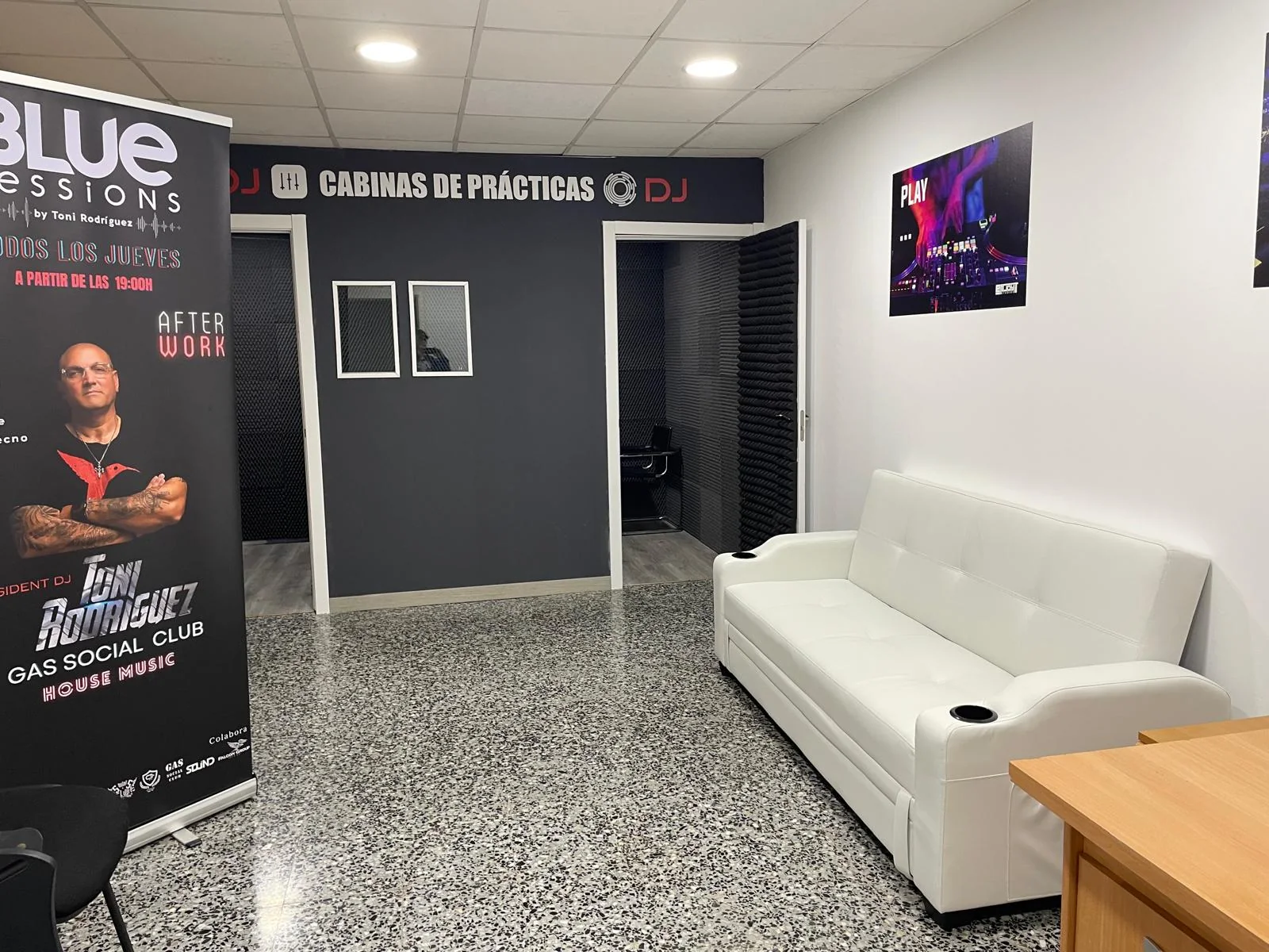 Zona de acceso a las cabinas con sofá y puertas insonorizadas